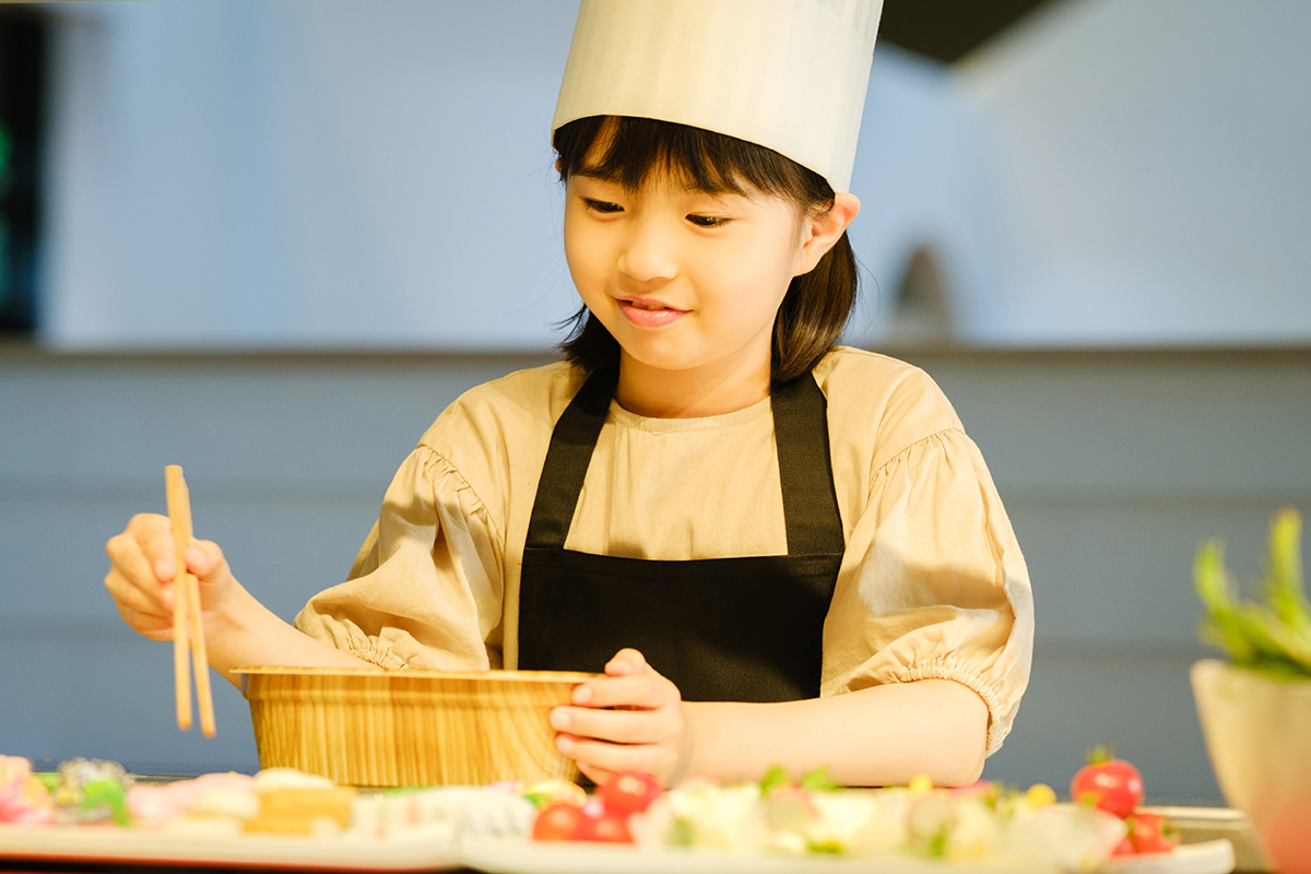 コック帽をかぶって、約50種のメニューからおかずを選ぼう